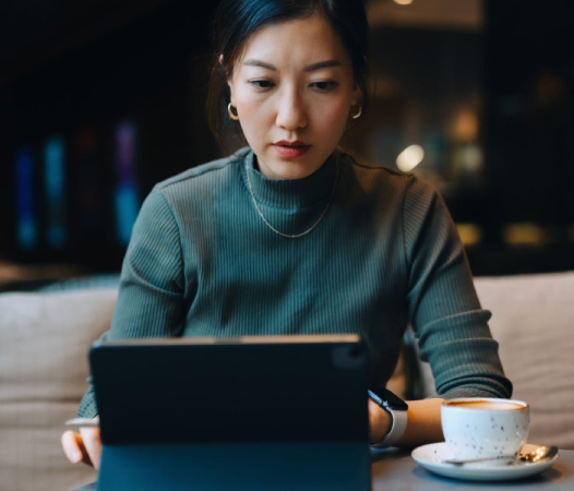 Woman using tablet in a café setting.